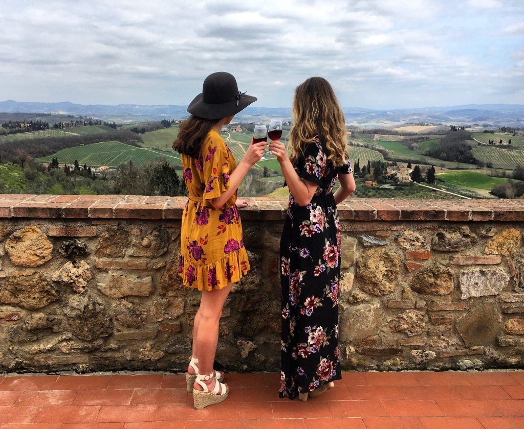 Two females with wine glasses in the wine region of Tuscany, Italy. 